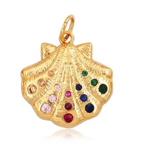 Détails d'un pendentif coquillage doré serti de pierres colorées et mesures de taille