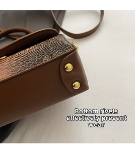 Close-up of vintage crocodile pattern handbag showing side gold rivets and leather texture