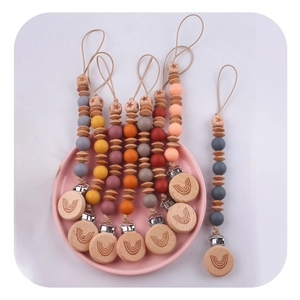 Colorful silicone and beech wood baby pacifier clips with rainbow patterns and metal clips