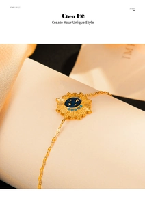 Macro detail of 14K gold star moon bracelet with blue enamel sun pendant over silk