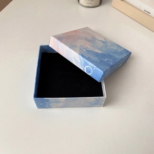 Open rectangular jewelry gift box with starry sky pattern and black velvet interior