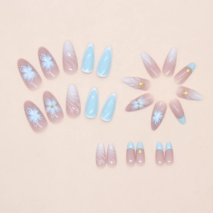 Close-up of blue marble press-on nails with 3D floral accents and gold bead details