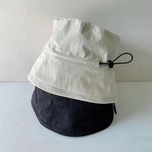 Detail of summer bucket hat showing adjustable drawstring toggles and cotton fabric texture