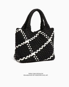 Detail of hand-woven retro tote bag with black and white checkered texture and dual handles