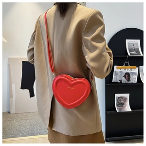 Sac à bandoulière rouge en forme de cœur porté par un mannequin pour montrer la taille