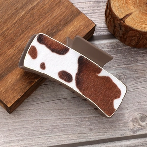 Rectangle matte cow print hair claw clip in brown leather pattern on wood background