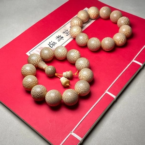 Dragon blood bamboo beaded bracelets on red book background with high density texture