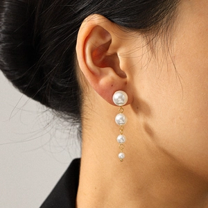 Boucles d'oreilles pendantes vintage en acier inoxydable doré 18k avec perles sur modèle