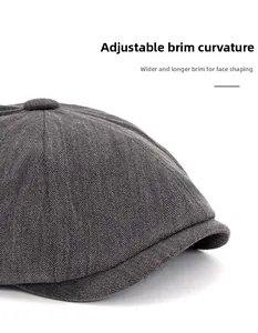 Detail of grey herringbone newsboy cap featuring wide foldable brim for face contouring
