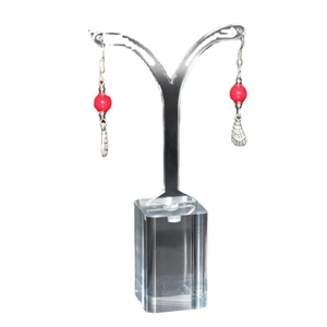 Acrylic jewelry stand showcasing red bead and silver metal drop earrings on a white background