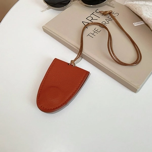 Close-up of orange-brown leather glasses case necklace with woven lanyard and soft texture