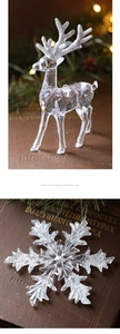 Detail of transparent acrylic Christmas reindeer and snowflake with silver glitter accents