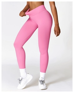 Detail of pink high-waisted yoga pants with cross-waist design and flatlock stitching