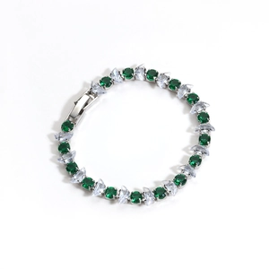 Detailed close-up of green and white zircon tennis bracelet with silver plating finish