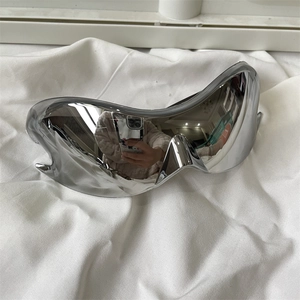 Detailed top view of futuristic silver mirrored cycling sunglasses on white fabric