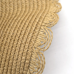 Vista de detalle de sombrero de paja con borde ondulado y textura de tejido de calidad