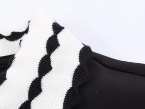 Macro view of the polo collar with black and white contrast knitting and wavy edge detail