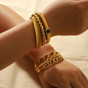 Détail de bracelets en acier inoxydable plaqué or 18 carats avec émeraudes et zircons