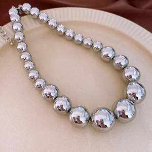 Macro shot of polished silver gradient ball beads on a luxury minimalist necklace