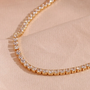 Macro detail of 14K gold plated tennis chain with brilliant round cut cubic zirconia stones