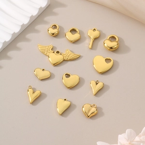 Flat lay of 11 golden heart pendants including winged designs for DIY jewelry making