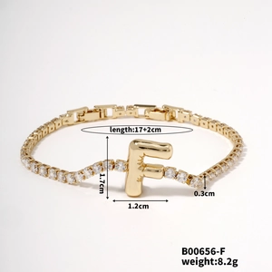 Detailed view of gold letter F bracelet featuring sparkling white zircon stones and tennis chain