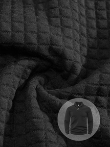 Close-up detail of the waffle knit texture and fabric on a black men's pullover sweatshirt