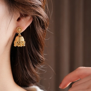 Detail of vintage gold-plated bell tassel earrings featuring hollow-out craftsmanship