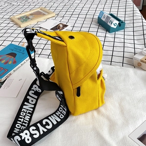 Yellow canvas crossbody chest bag with lettered strap on a minimalist plaid background