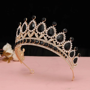 Dettaglio macro della lussuosa tiara barocca dorata con cristalli neri e strass lucidi