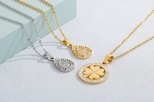 Detail of gold and silver clover pendants with sparkling rhinestones on sleek metal chains