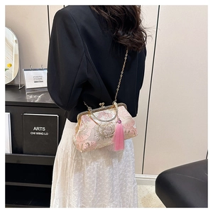 Detail of elegant peony embroidery on beige shell bag with gold chain and tassel
