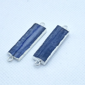 Macro view of blue kyanite rectangle stone pendants with silver-plated metal edges
