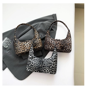 Detailed view of three leopard print hobo bags in brown and grey tones on grey blazer