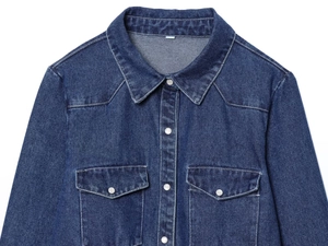 Close-up of deep blue denim jacket showing classic collar, dual chest pockets, and metal buttons