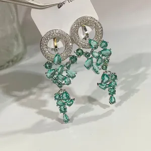 Détail macro de boucles d'oreilles en argent S925 avec pierres vert émeraude taille poire