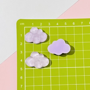 Macro shot of 3cm translucent resin cloud charms for DIY crafts on a measuring mat