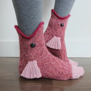 Close-up of pink knit fish socks with 3D scale texture, fins and button eyes detail