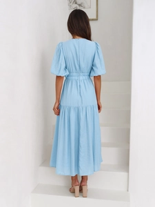 Back view of light blue puff sleeve midi dress with elastic waist and flowing skirt