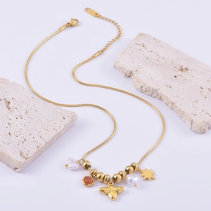 Gold bee and star pendant necklace with pearls and red beads on snake chain