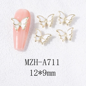 Vue macro des breloques 3D pour ongles en forme de papillon avec bordure dorée
