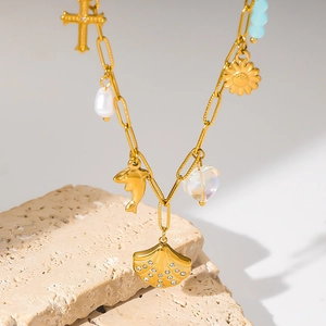 Golden multi-pendant necklace with dolphin, pearl, and rhinestone scallop charm
