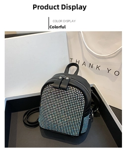 Detail of a mini black leather backpack with colorful iridescent rhinestones in a gift box