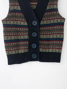 Dettaglio del gilet in maglia jacquard geometrica con motivi vintage e bordi blu
