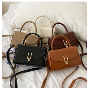 Detailed arrangement of five colorful vintage crossbody bags on a white linen surface