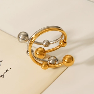 Detail of multi-layer spiral ring featuring two-tone gold and silver metal spheres