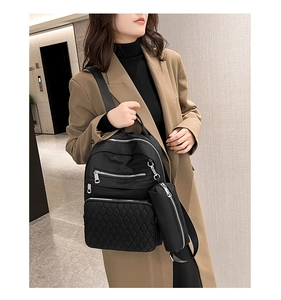 Vue détaillée du sac à dos en nylon matelassé noir avec petite poche, style décontracté.