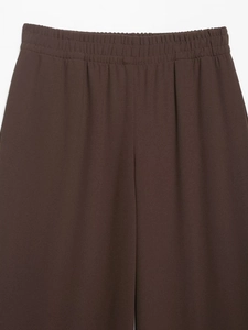 Detail view of brown textured trousers featuring an elastic high waist design for comfort
