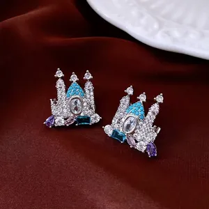 18K gold-plated castle stud earrings with blue zircon crystals on a red velvet background