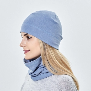 Close-up of light blue knitted beanie and neck gaiter set on a model for winter warmth